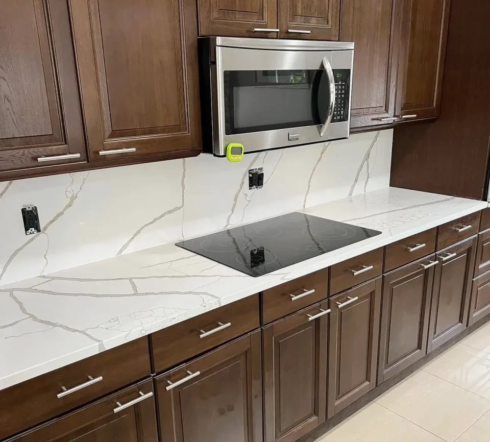 white stone counter with brown cabinets