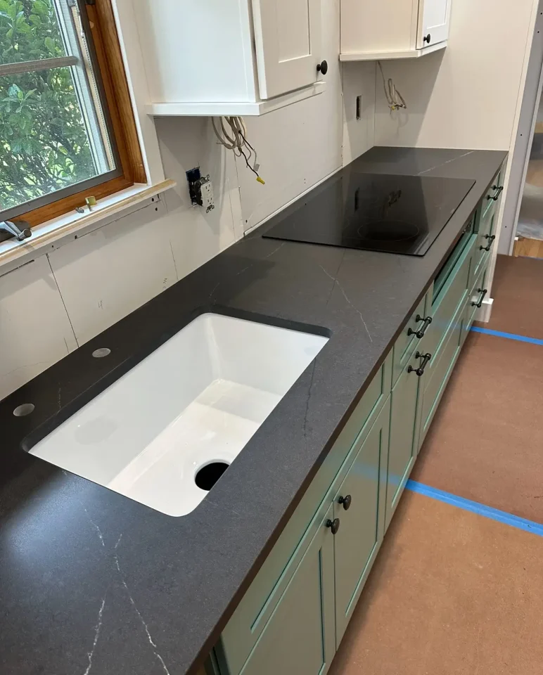 dark stone with green cabinets